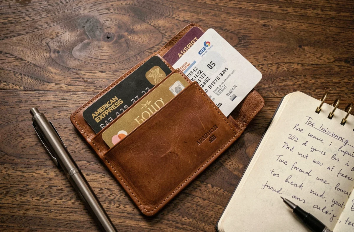 Flat-lay de la carte American Express Gold avec passeport, carte d'embarquement et certificat d'assurance voyage