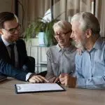 Excited mature couple sign contract with realtor