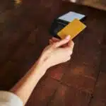 female-hand-holding-yellow-plastic-bank-ca