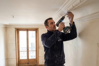 Technicien installant une alarme dans un appartement haussmannien avec moulures en stuc