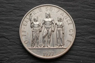 Gros plan macro d'une pièce authentique en argent 50 Francs 1977 montrant les détails du relief Hercule sur fond ardoise sombre